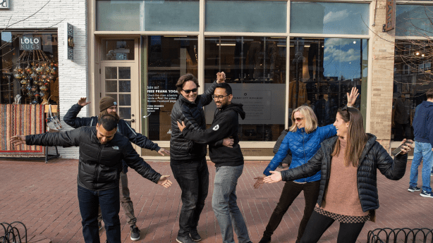 photo of TeamSnap employees outside, dancing together.