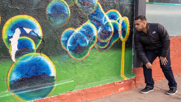 photo of a man near a mural