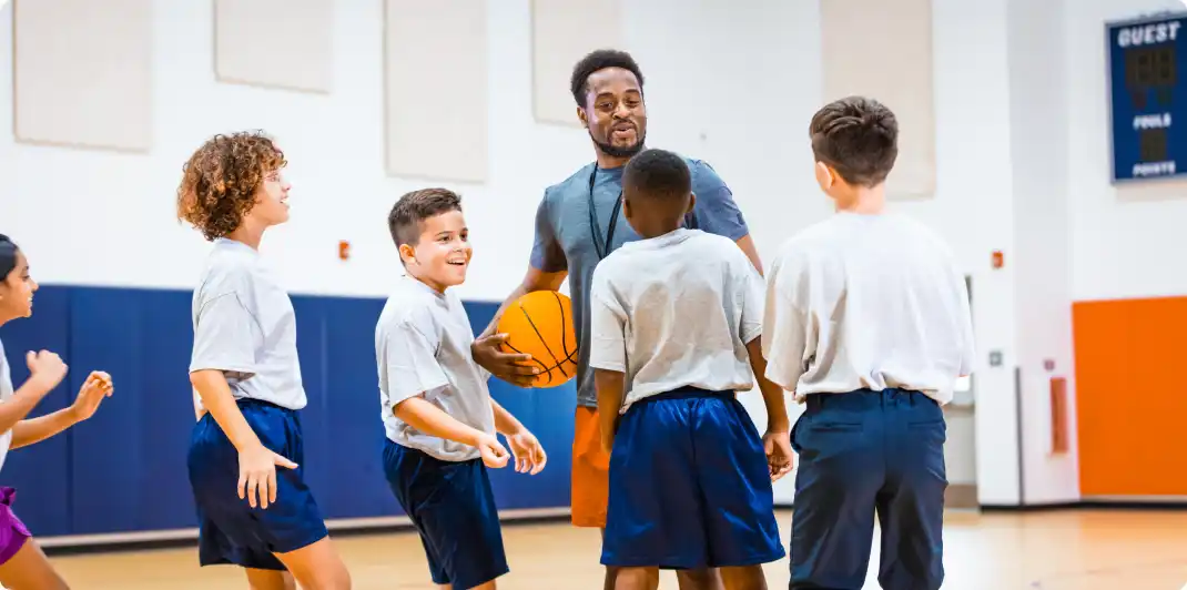 Photo of a male basketball coach talking to his youth team