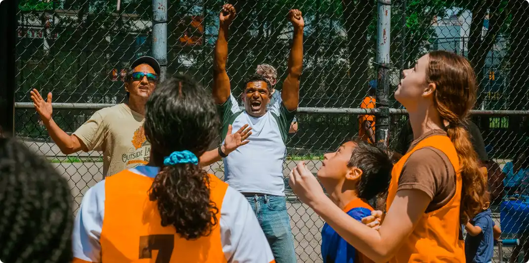 Photo of a youth basketball team with the parents in the background