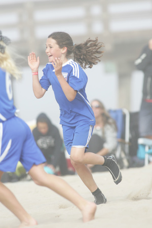 photo of little girl running in sand